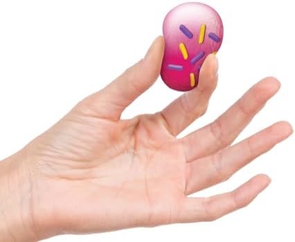 Hand squeezing a miniature Schylling donut hole toy to demonstrate the soft pliable dough filling.