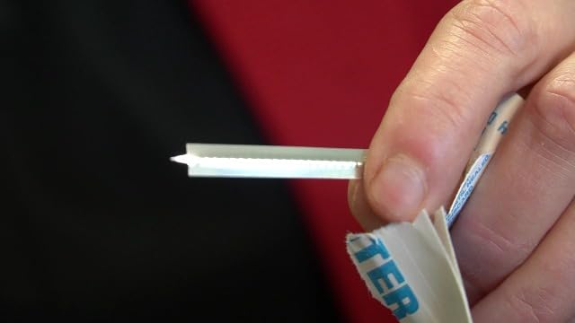 Stainless steel splinter out tool being removed from sterile wrapper