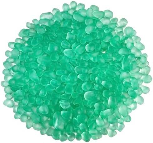 Smooth green sea glass pebbles arranged inside a small fish tank showing underwater clarity and shimmer