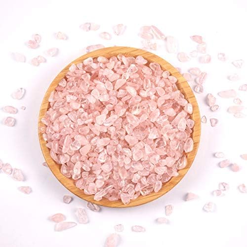 Hand holding a handful of natural irregular pink quartz stones