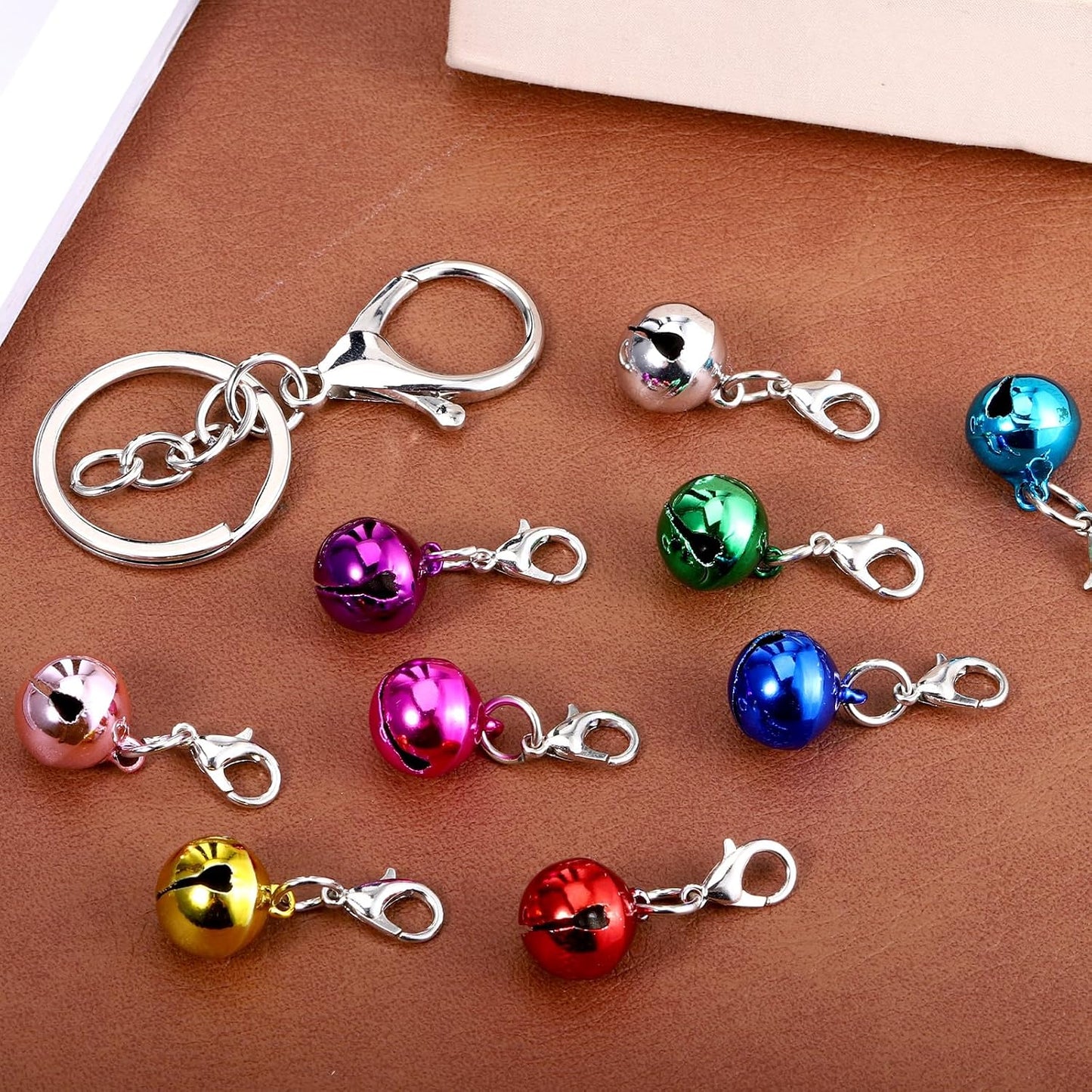 Complete package contents including nine pieces of colorful pet bells and one sturdy keychain hook.