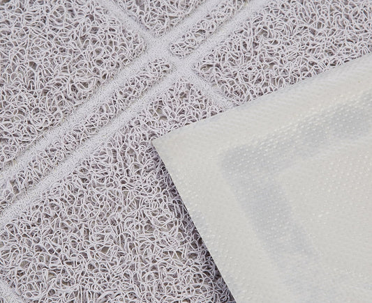 Close-up of the diamond-patterned grooves on the grey PVC litter mat.