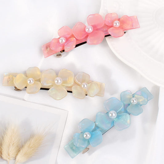 Three pieces of rectangular snap hair clips for thick hair displayed on a flat surface