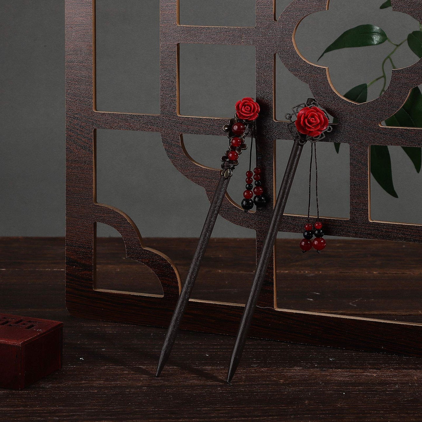 A pair of handmade floral wooden hair sticks showcasing the unique patterns and detailed styling elements.