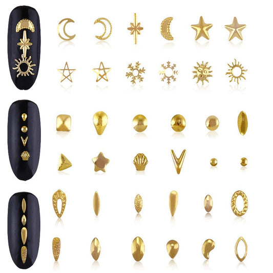 Close-up of gold metal star and moon charms for fingernail decoration