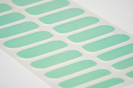 Pink and green iridescent gel nail strip design close up