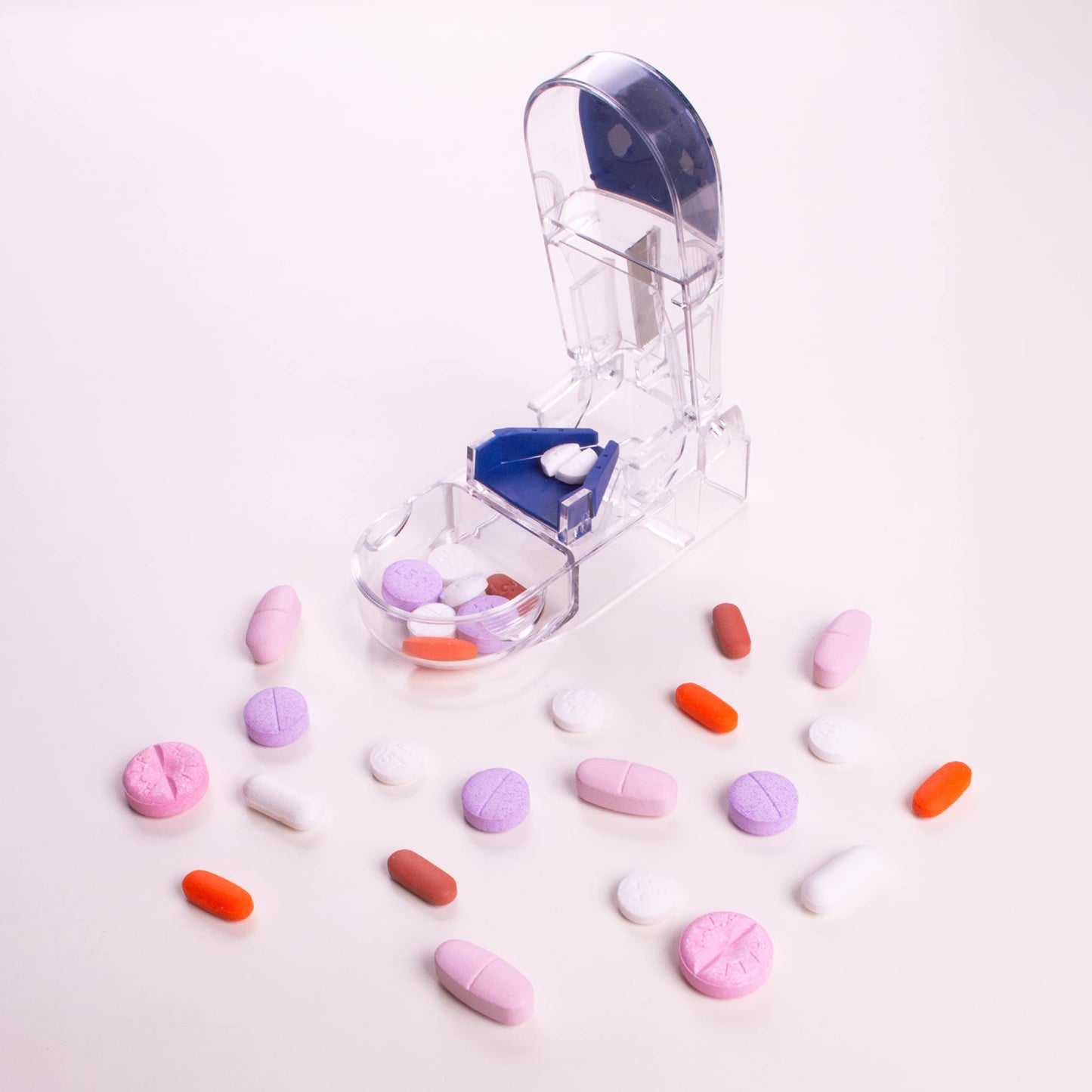 Compact medical pill splitter placed next to a travel pouch showing its portable size.