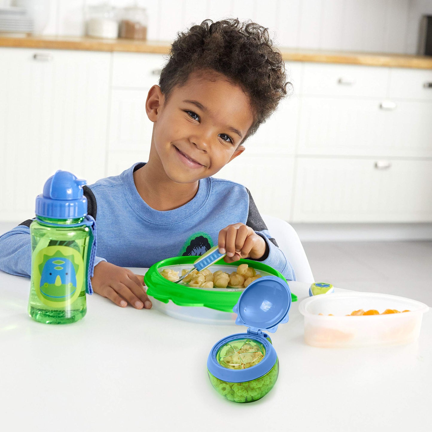 Skip Hop Dino snack cup attached to stroller handle for travel