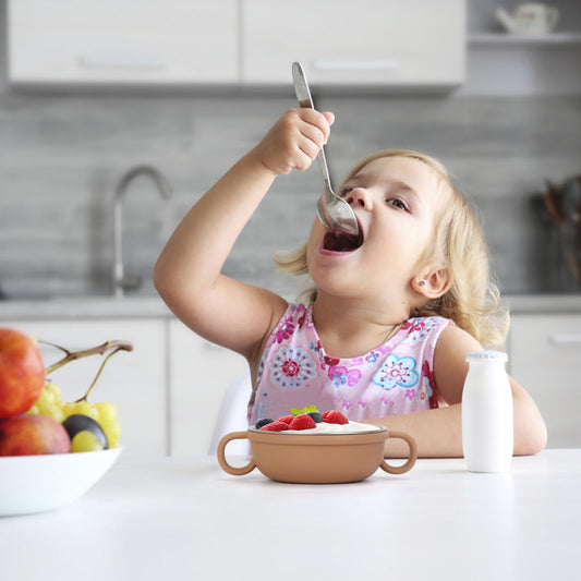 Close up of stainless steel baby bowl with colorful removable silicone sleeve