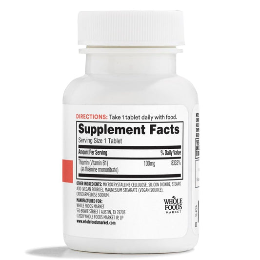 Side angle of Whole Foods Market 100 milligrams Thiamin dietary supplement showing vegan product certification labels