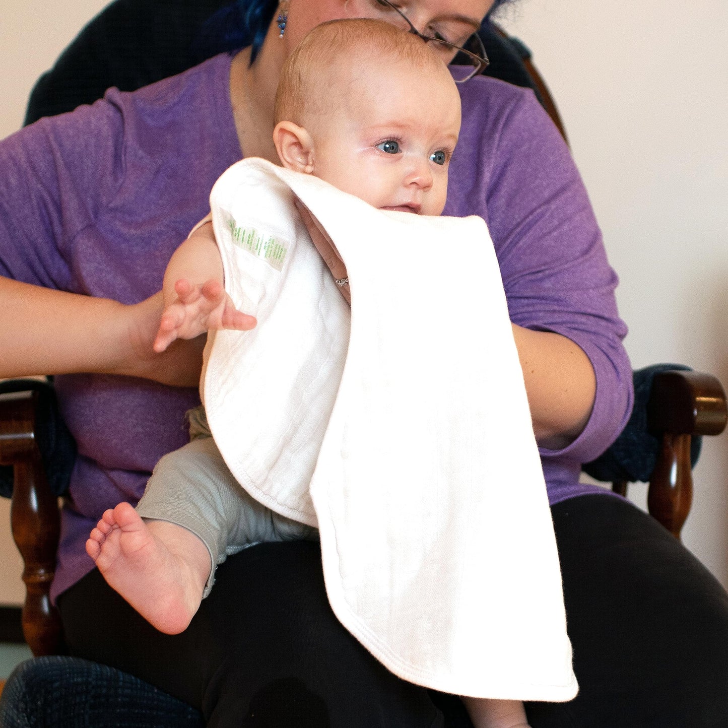 Parent using contoured burp cloth for baby feeding