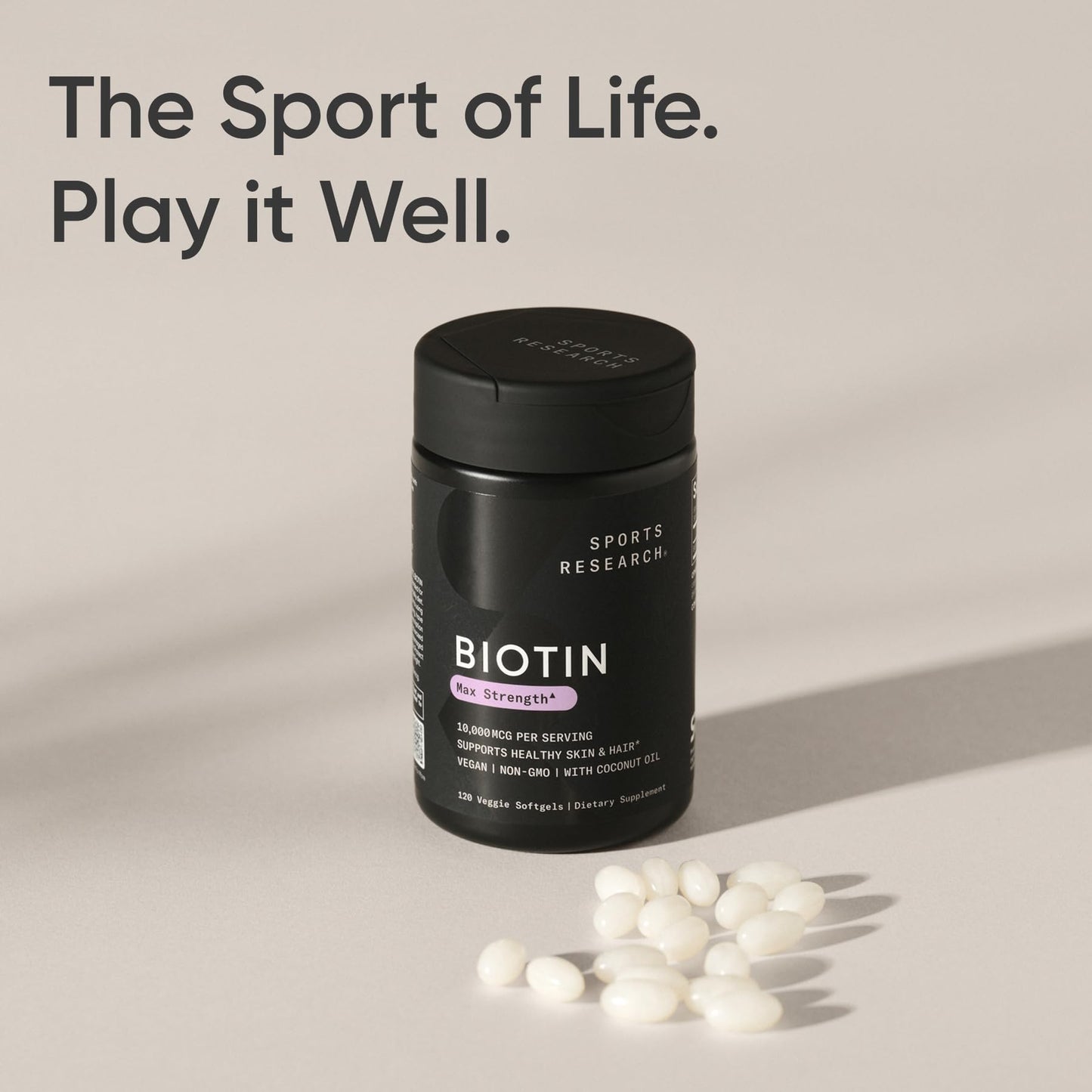 Sports Research extra strength biotin supplement bottle shown next to fresh organic coconuts representing ingredients