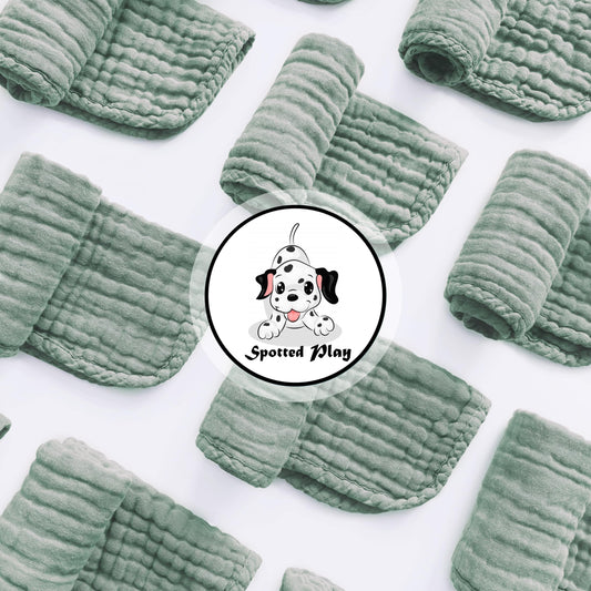Twelve pack of extra soft green muslin spit up rags neatly stacked for nursery organization.