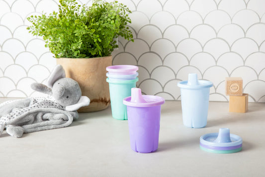 Stacked pastel colored toddler cups with snap-on lids showcasing the space-saving storage design.