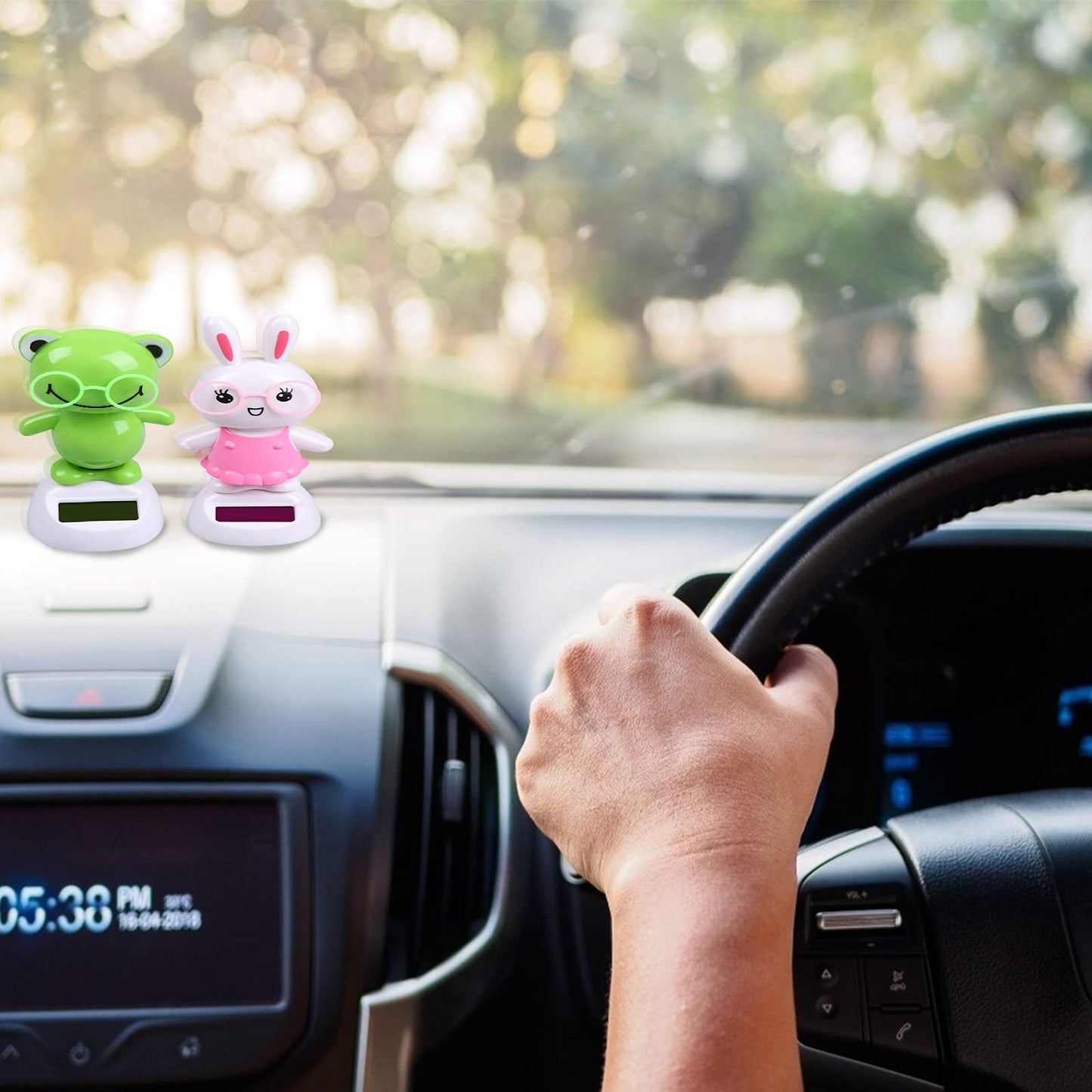 Welecom solar powered bobbleheads installed securely on a car dashboard interior.