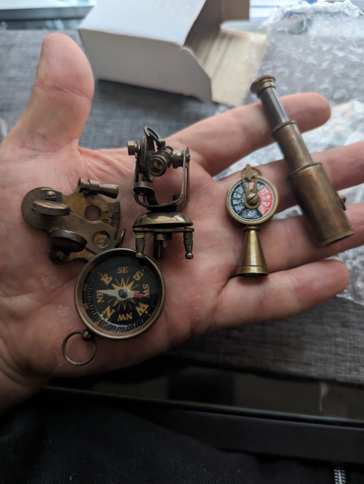 Angled view of the full five piece miniature nautical instrument collectible set on a study desk