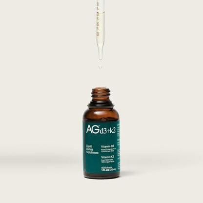 AG1 Vitamin D3 K2 drops being added to a glass of water