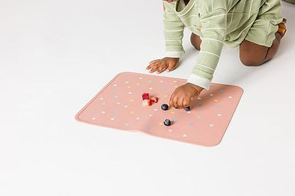 Toddler placemat being cleaned under warm soapy running water
