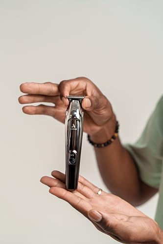 Andis Slimline Pro II trimmer held in hand showing size and scale