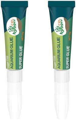 Two tubes of clear fish safe reef adhesive gel displayed next to live aquarium plants and rocks.