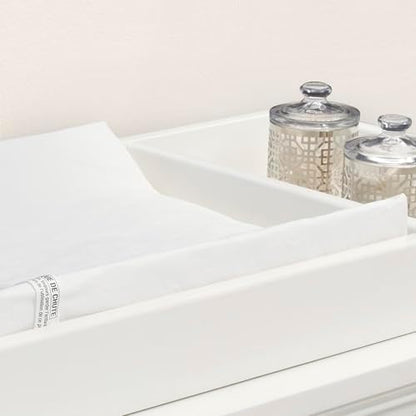 White Delta Children changing pad with contoured safety sides