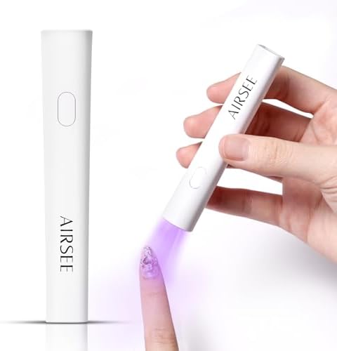 AIRSEE portable nail lamp being held over a finger curing a rhinestone extension