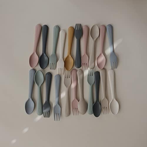 Toddler using Mushie sage fork and spoon set