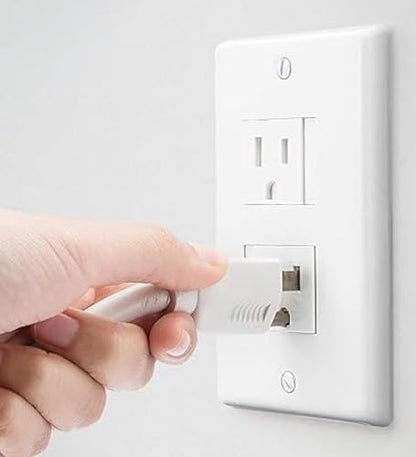 Side profile of white self-closing outlet cover installed on wall
