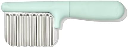OXO Tot toddler food cutter slicing an avocado on a cutting board