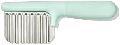 OXO Tot toddler food cutter slicing an avocado on a cutting board