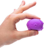 Hand squeezing a miniature Schylling dog squish toy to demonstrate its slow-rebound texture