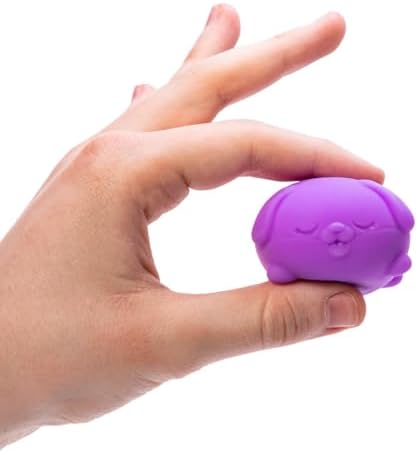 Hand squeezing a miniature Schylling dog squish toy to demonstrate its slow-rebound texture
