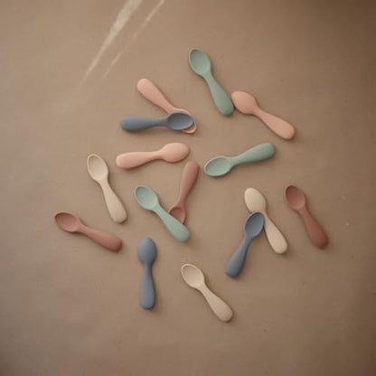 Close up shot of the ergonomic easy grip handles on Mushie silicone training spoons for toddlers