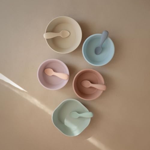 Two pack of Mushie toddler self feeding spoons in Shifting Sand and Blush colors displayed together