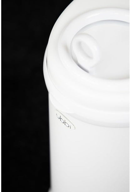 Ubbi diaper pail showing the sliding lid and childproof lock mechanism