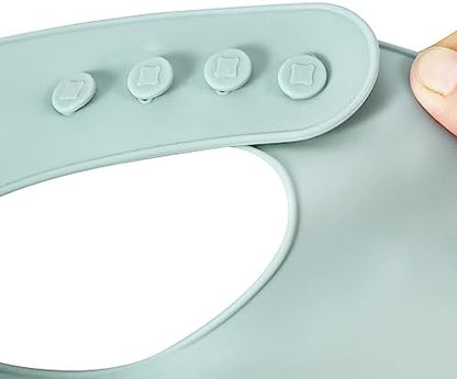 PandaEar food grade BPA free silicone baby bib being wiped clean with a kitchen cloth