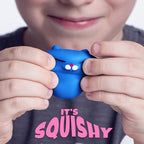 Two inch soft silicone miniature cat fidget toys being squeezed for anxiety relief.