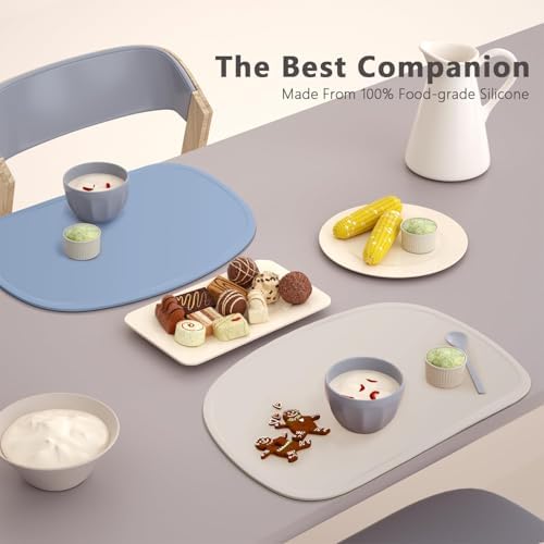 Toddler eating independently on the non slip baby food mat at a home dining table.