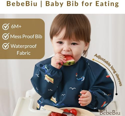 The built-in food catcher pocket of the BebeBiu long sleeve bib trapping falling crumbs during mealtime.