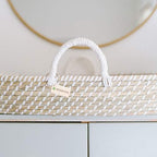 Handwoven changing basket displaying integrated handles and waterproof sheet