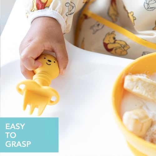 Baby holding Bumkins Disney silicone Chewtensils during self-feeding
