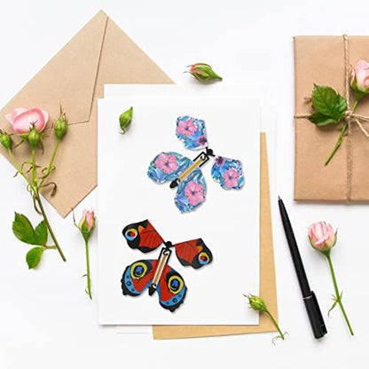 Multiple colorful rubber band powered butterflies flying out of an open birthday greeting card