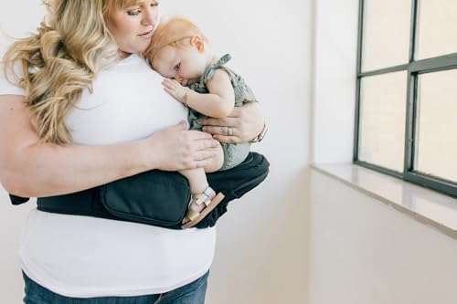 Caregiver adjusting the premium plastic safety buckle on the Tushbaby black extension strap.