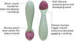Infant holding the short round non slip silicone handle easily.