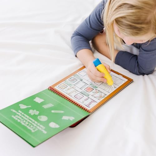 Toddler hands holding the chunky water pen over the mess free coloring book pages.
