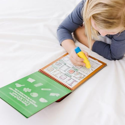 Toddler hands holding the chunky water pen over the mess free coloring book pages.