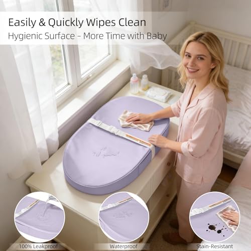 Cushioned diaper changing mat on a nursery dresser with the safety belt secured.
