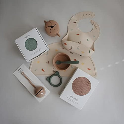 Mushie adjustable silicone bib showing the four built-in neck fasteners