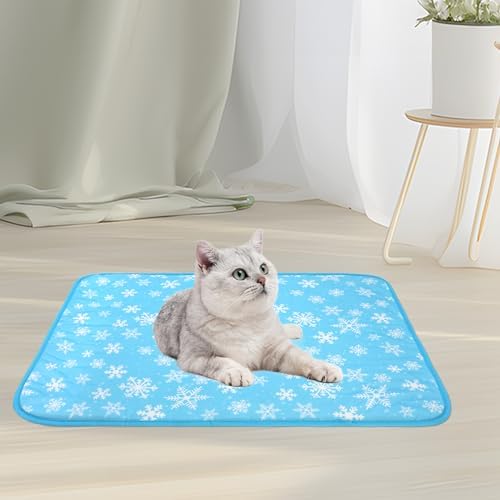 A fluffy domestic cat relaxing comfortably on top of the blue NACOCO snowflake cooling mat.