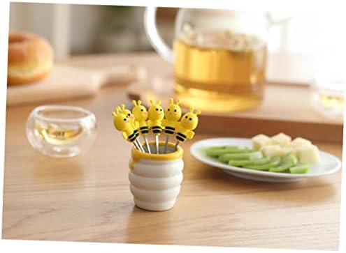 Top angle view of bee themed dessert picks inside ceramic holder